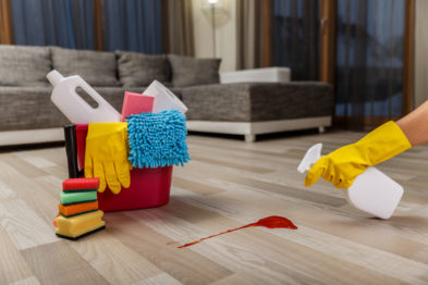 Cleaning service. Bucket with sponges, chemicals bottles and plunger. Hand in rubber glove holding a spray. Paper towel. Red splash spot. Cleaning service. Bucket with sponges, chemicals bottles and plunger. Hand in rubber glove holding a spray. Paper towel. Red splash spot.